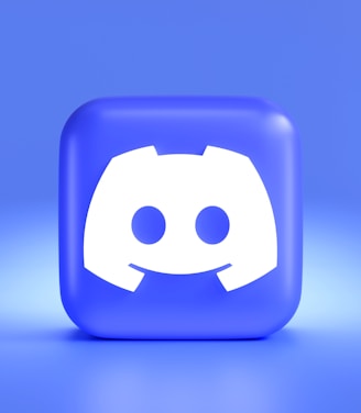 A three-dimensional blue cube featuring a white, stylized gaming controller symbol associated with a popular communication platform, set against a gradient blue background.